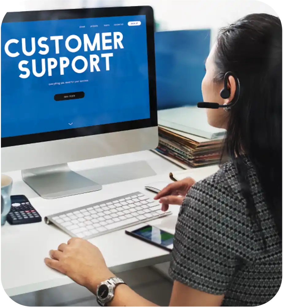 Customer support representative assisting users through a headset at a desktop workstation.