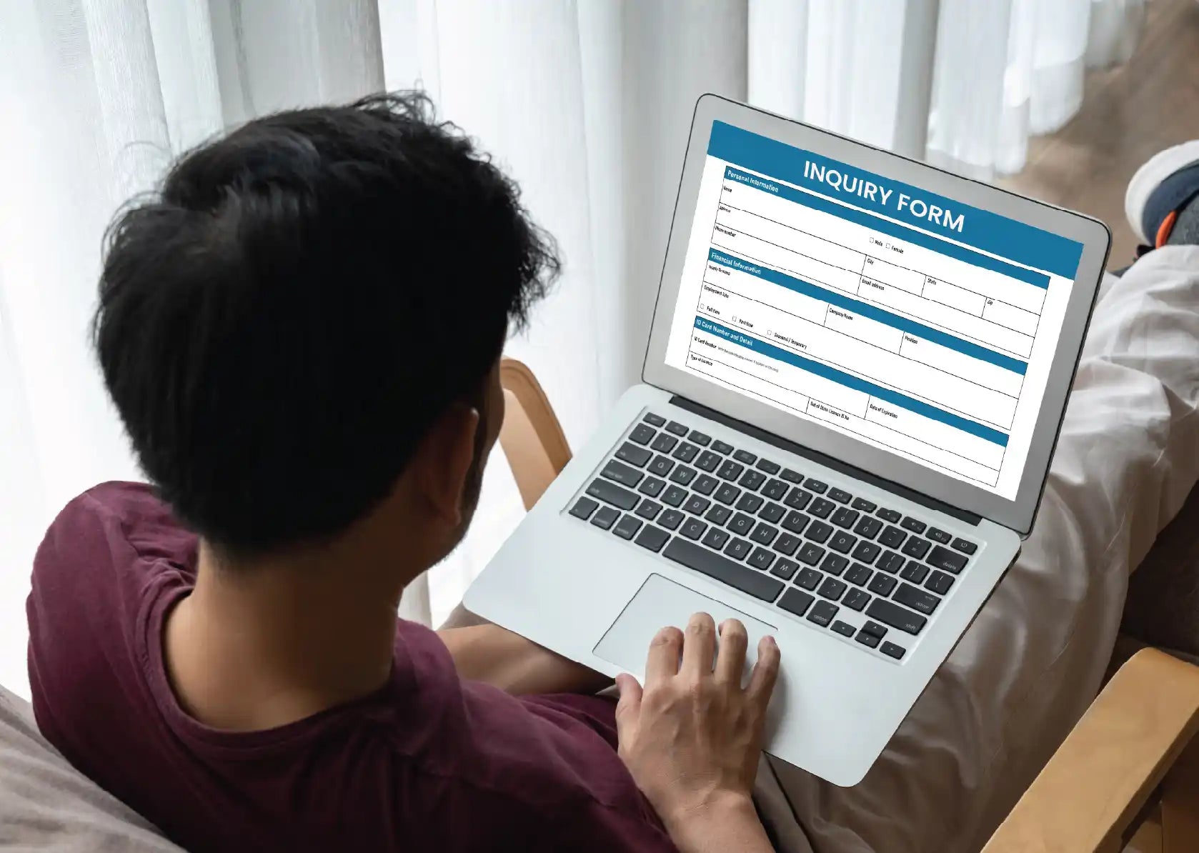 Person completing an online inquiry form on a laptop as part of the dealer application process.