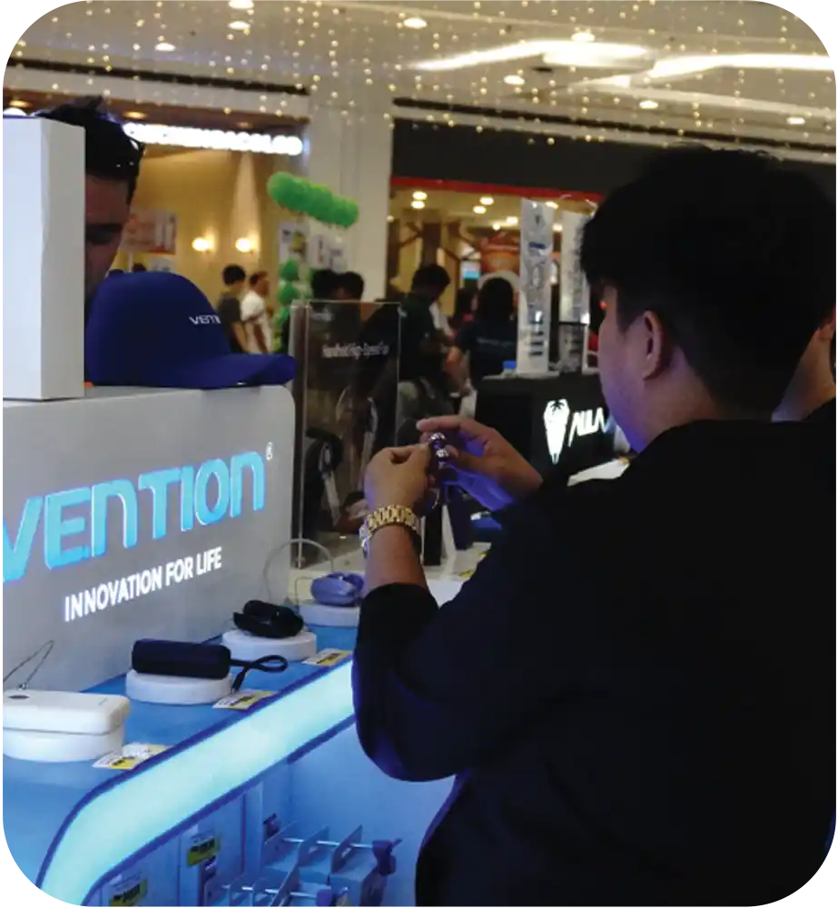 In-store demonstration of Vention electronic accessories at a branded retail kiosk.